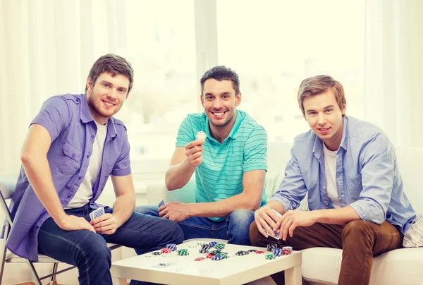 Glad tre manliga vänner spela poker hemma — Stockfoto