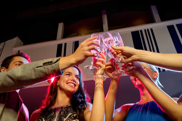 Lachende vrienden met glazen van champagne in club — Stockfoto