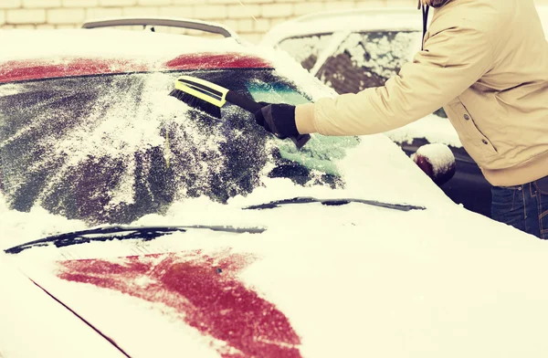 Primer plano del hombre limpiando la nieve del coche —  Fotos de Stock