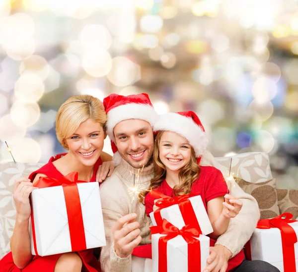 Familia feliz en sombreros de santa helper con cajas de regalo —  Fotos de Stock