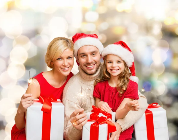 Família feliz em santa helper chapéus com caixas de presente — Fotografia de Stock