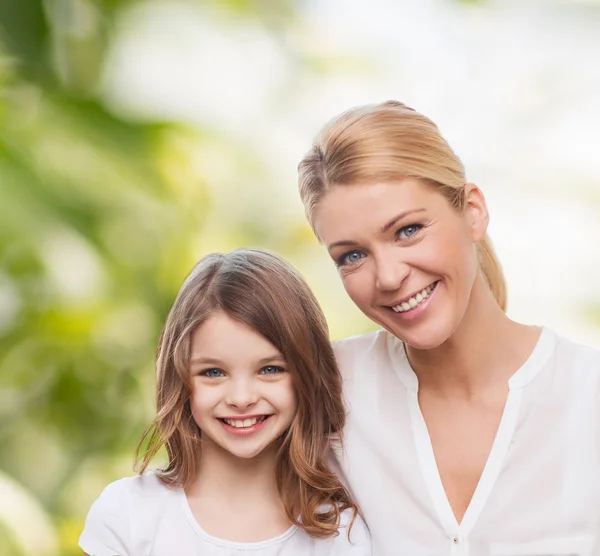 Lächelnde Mutter und kleines Mädchen — Stockfoto