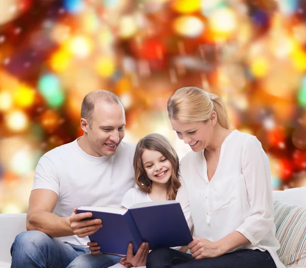 Família feliz com livro em casa — Fotografia de Stock