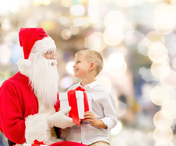 Усміхнений маленький хлопчик з Сантою Клаус і подарунками — стокове фото
