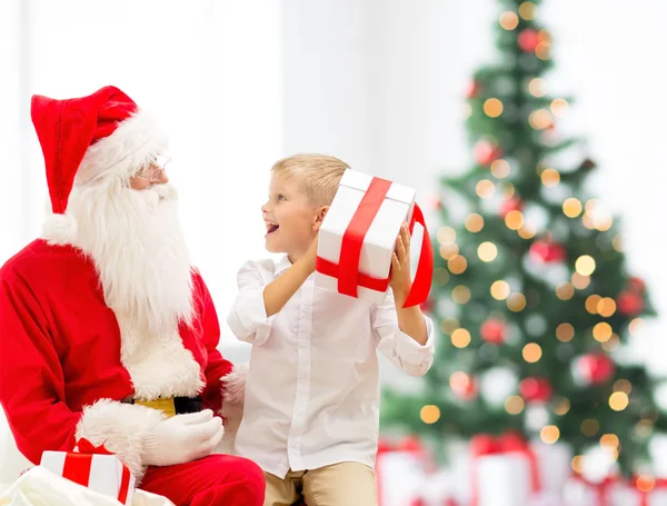 Lachende jongetje met santa claus en giften — Stockfoto