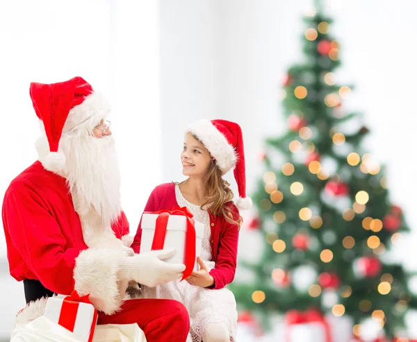 Niña sonriente con santa claus y regalos — Foto de Stock