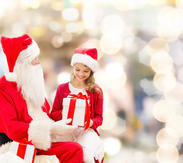 Uśmiechnięta dziewczynka z santa claus i prezenty — Zdjęcie stockowe