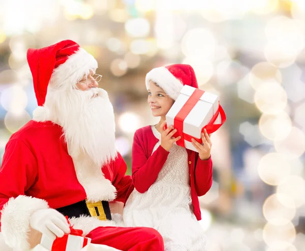 Niña sonriente con santa claus y regalos — Foto de Stock