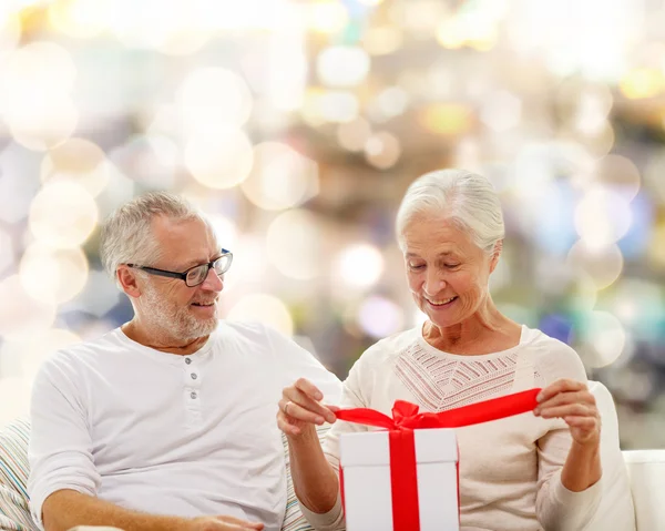 Heureux couple aîné avec boîte cadeau à la maison — Photo