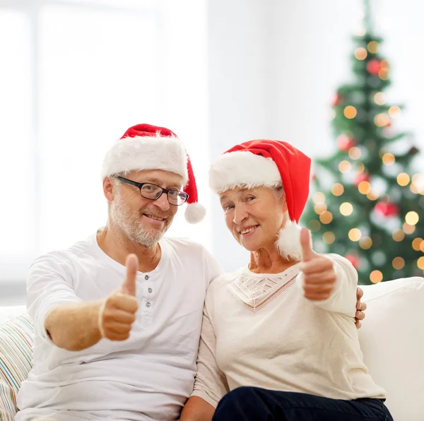 Šťastný starší pár v santa pomocníka klobouky — Stock fotografie