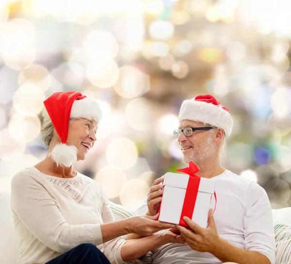 Gelukkig senior paar met geschenkdoos thuis — Stockfoto