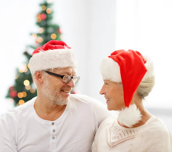 Happy senior couple in santa helper hats — Stock Photo, Image