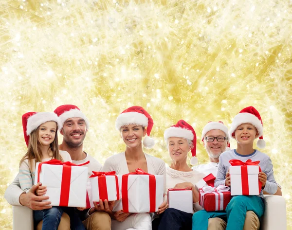 Happy family in santa helper hats with gift boxes — Stock Photo, Image