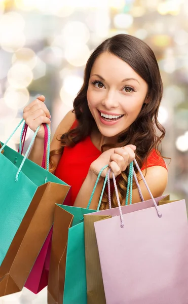 カラフルな買い物袋を持つ女性の笑みを浮かべてください。 — ストック写真