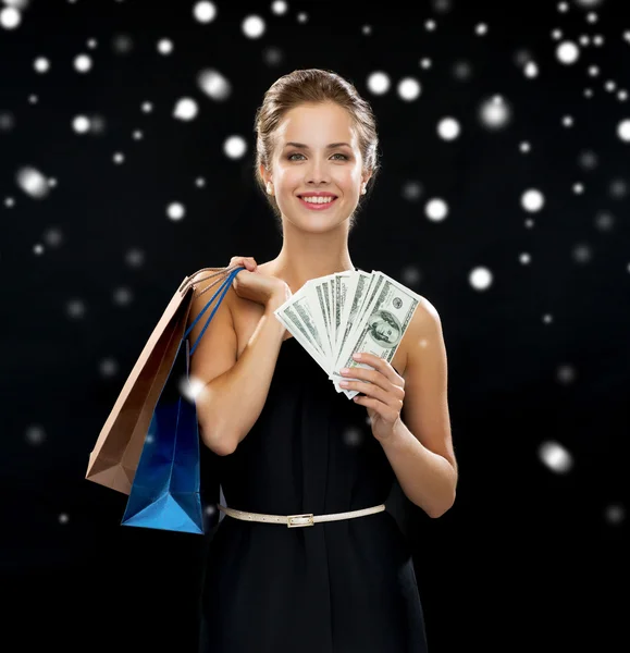 Mulher sorridente no vestido com sacos de compras — Fotografia de Stock