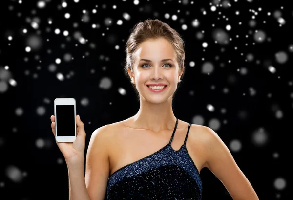 Femme souriante en robe de soirée tenant smartphone — Photo