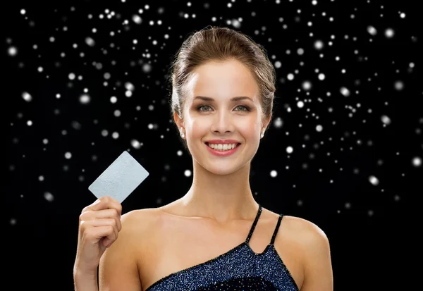 Smiling woman in evening dress holding credit card — Stock Photo, Image