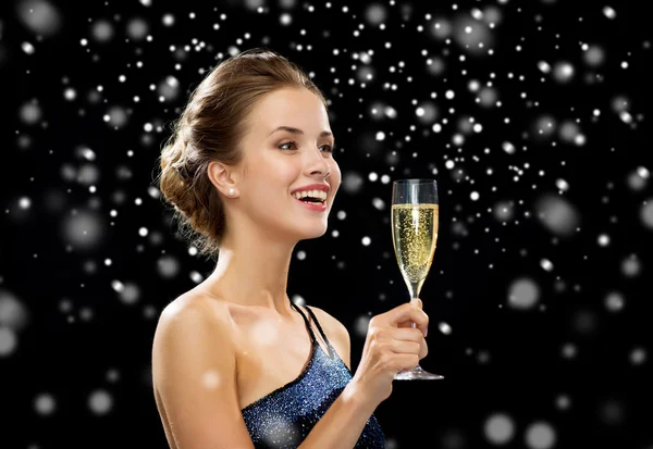 Sonriente mujer sosteniendo un vaso de vino espumoso —  Fotos de Stock