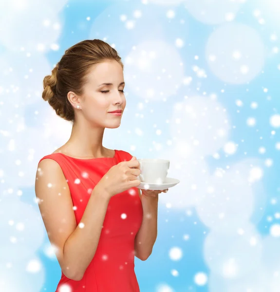 Mujer sonriente en vestido rojo con taza de café — Foto de Stock