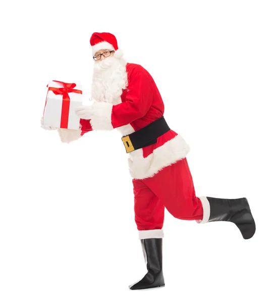 Mies puvussa joulupukki lahjapakkauksessa — kuvapankkivalokuva