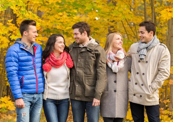 Grup gülümseyen kadın ve erkek sonbahar park — Stok fotoğraf