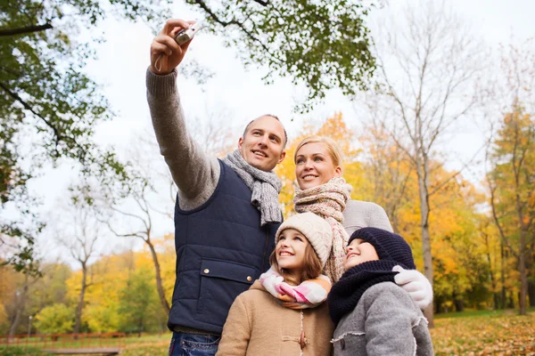 Familia feliz con la cámara en el parque de otoño — Foto de Stock