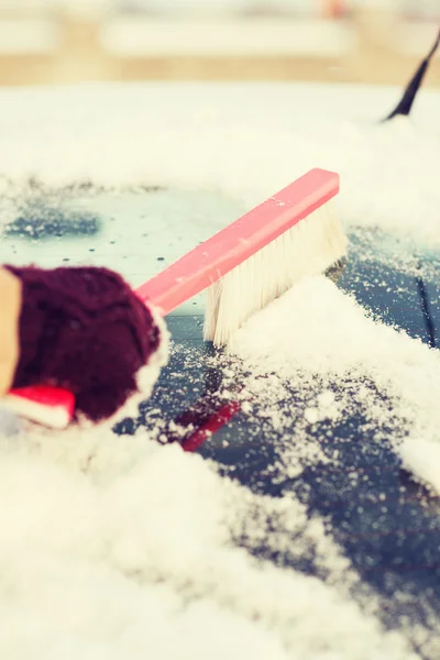 Mujer limpiando nieve de la ventana trasera del coche — Foto de Stock