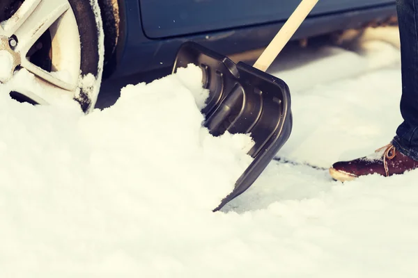 Closeup of man digging up stuck in snow car — Stock Photo, Image