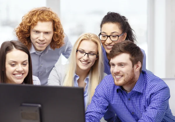 Smiling business team looking at computer monitor — Stock Photo, Image