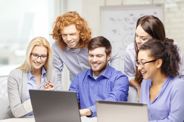 微笑与笔记型电脑在办公室的团队 — 图库照片