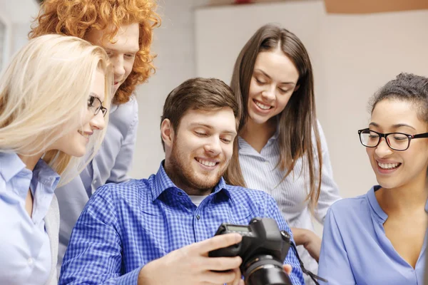 Equipo sonriente con cámara fotográfica en la oficina — Foto de Stock