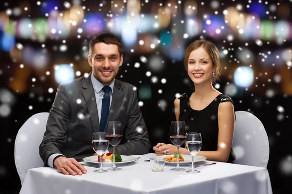 Sonriente pareja comiendo plato principal en restaurante — Foto de Stock