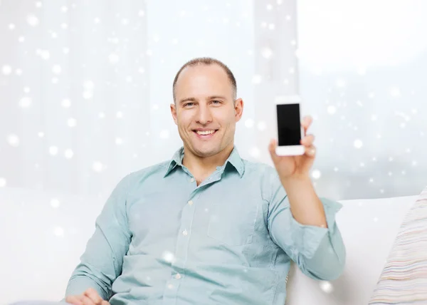 Homem sorridente mostrando tela de smartphone em branco — Fotografia de Stock