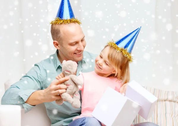 Pai e filha em bonés de festa com caixa de presente — Fotografia de Stock