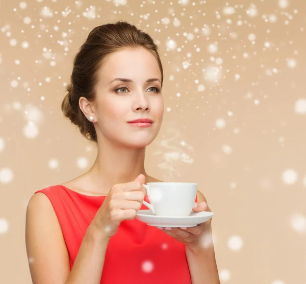Усміхнена жінка в червоній сукні з чашкою кави — стокове фото