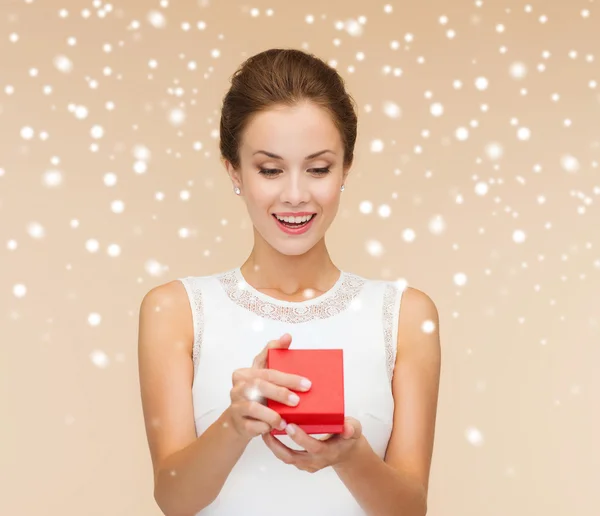 Mujer sonriente sosteniendo caja de regalo roja — Foto de Stock