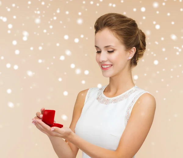 Χαμογελαστή γυναίκα που κρατά κόκκινο δώρο κουτί με δαχτυλίδι — Φωτογραφία Αρχείου