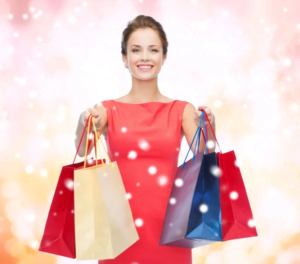 Femme élégante souriante en robe avec des sacs à provisions — Photo