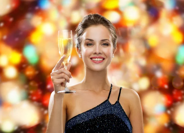 Sonriente mujer sosteniendo un vaso de vino espumoso —  Fotos de Stock