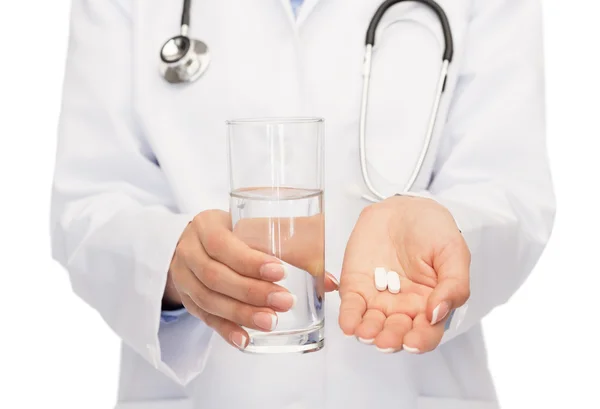 Close up of doctor offering pills and water — Stock Photo, Image