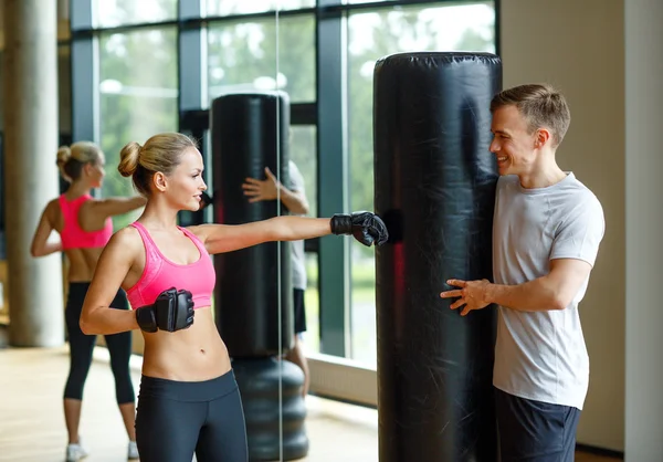 Mujer sonriente con entrenador personal boxeo en el gimnasio —  Fotos de Stock