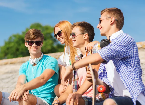 Grupo de amigos sonriendo sentados en la calle de la ciudad — Foto de Stock