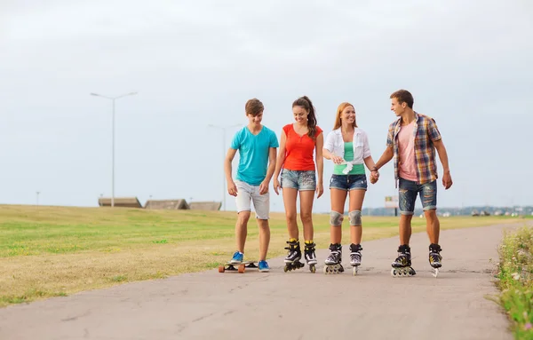 Grupp leende tonåringar med roller-skates — Stockfoto