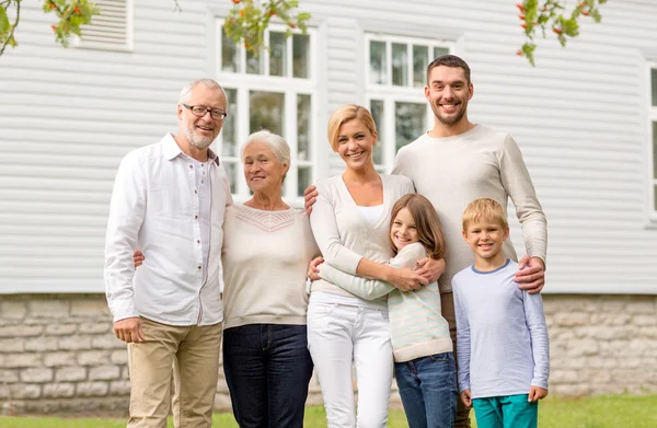 Família feliz na frente da casa ao ar livre — Fotografia de Stock