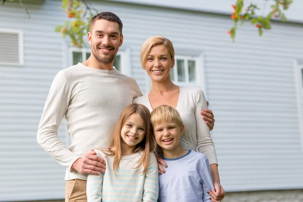 Família feliz na frente da casa ao ar livre — Fotografia de Stock