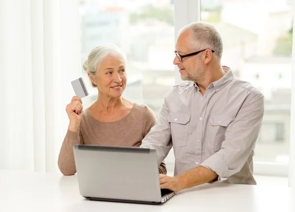 Casal sênior feliz com laptop e cartão de crédito — Fotografia de Stock