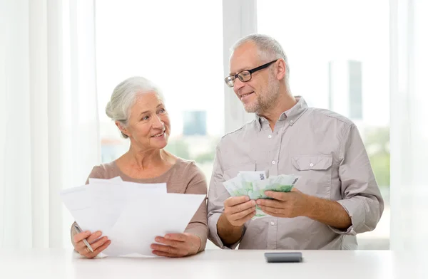 Senior couple with money and calculator at home — Stock Photo, Image