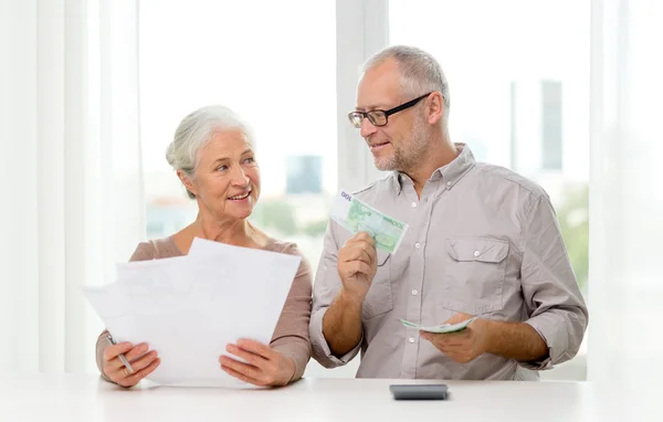 Senior paar met geld en rekenmachine thuis — Stockfoto