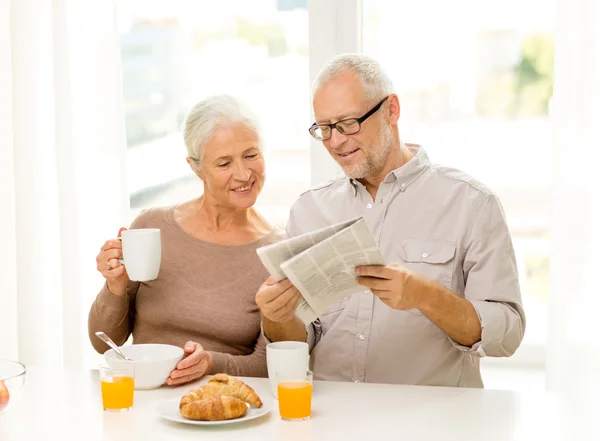 Happy senior couple having breakfast at home — Stock Photo, Image
