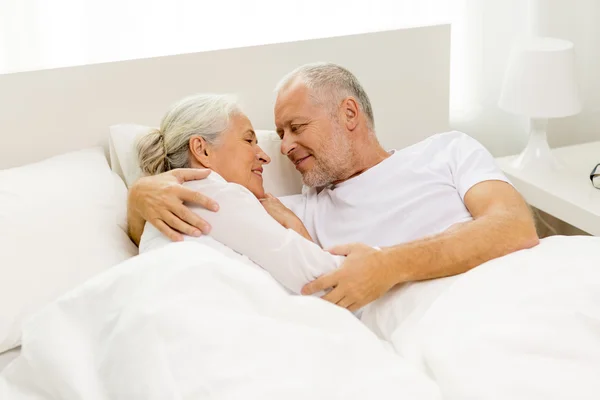 Happy senior coupler lying in bad at home — Stock Photo, Image